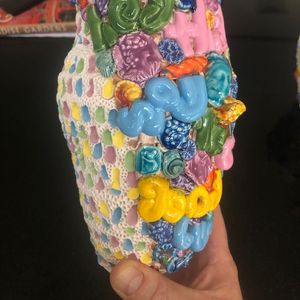 Colourful ceramic pot held in the artists hand