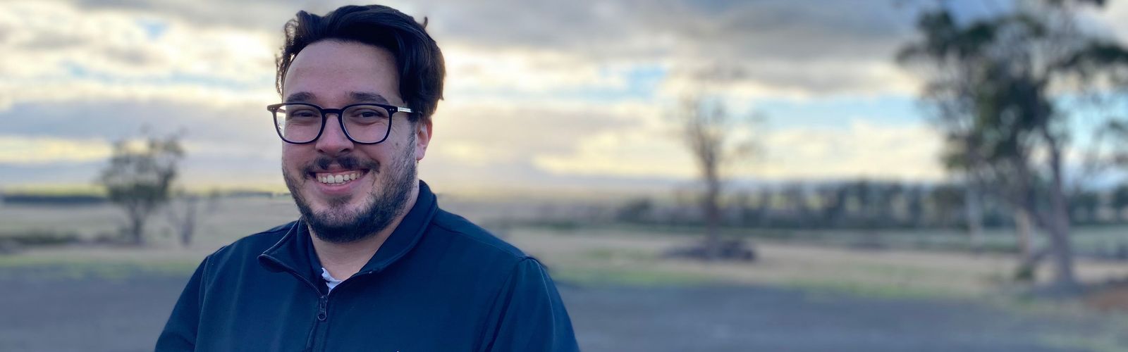 RFDS Tasmania's Physical Health Worker, Lachlan infront of a sunrise.