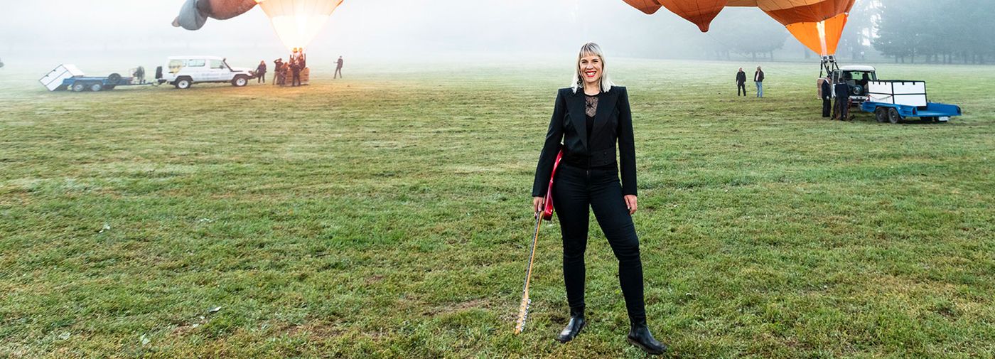 photo of Jess Green holding guitar in front of skywhale balloons
