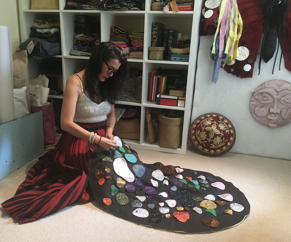 A photo of the artist, Soraya Abidin, working on her textile piece, The Miner's Wife, in her studio