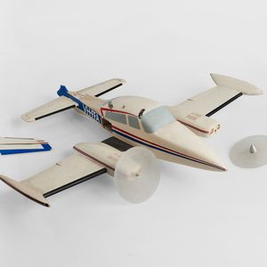 Photo of a model plane with the wing and propeller broken off on a white background.