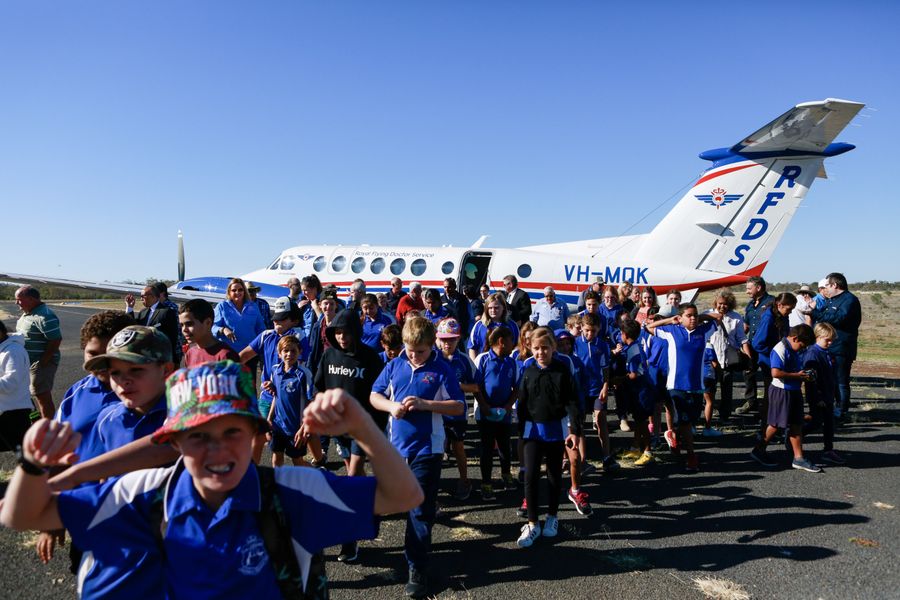 Excited school children in front of RFDS plane