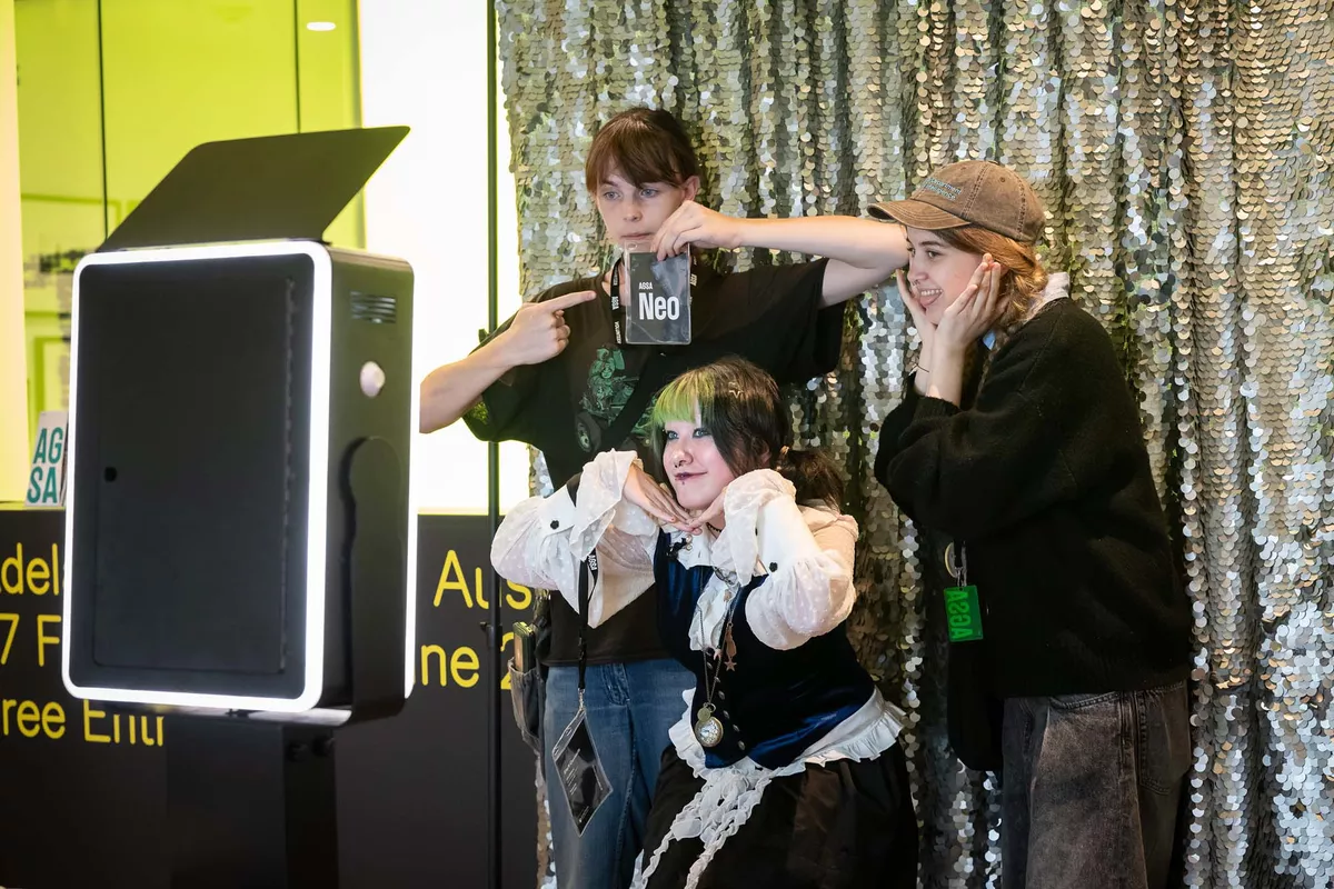 Group of three young people. posing in a photobooth.