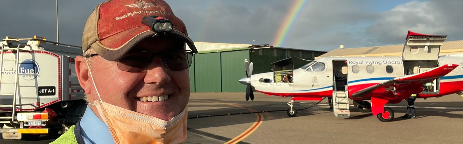 Pilot Simon Phelps taking a selfie infront of an aircraft.