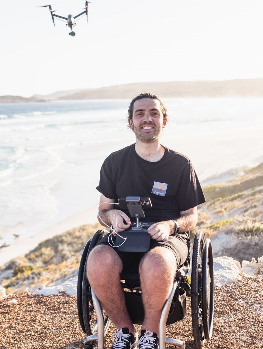 Jaimen sitting in his wheelchair while operating a drone.