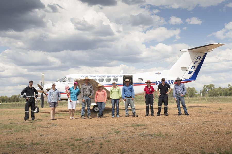 Community in front of a plane