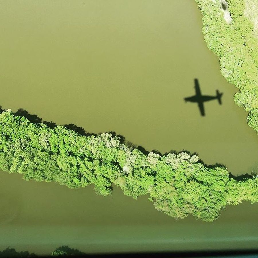 shadow of rfds plane as it flies over a river