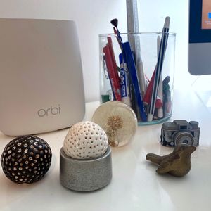 A collection of objects on a desk beside a computer monitor