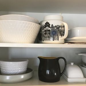 A kitchen cupboard filled with ceramic serving ware