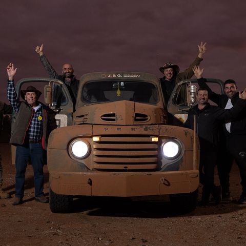 Trekkers posing around vehicle at dusk