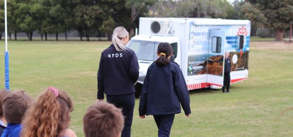 RFDS Tasmania Dental Coordinator with student walking towards mobile dental van.