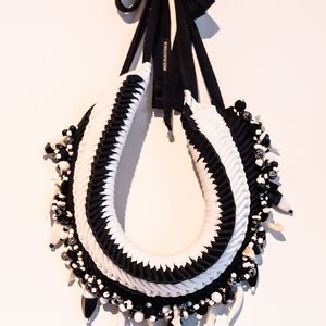 photo of a woven neckpiece made of fabric with beads