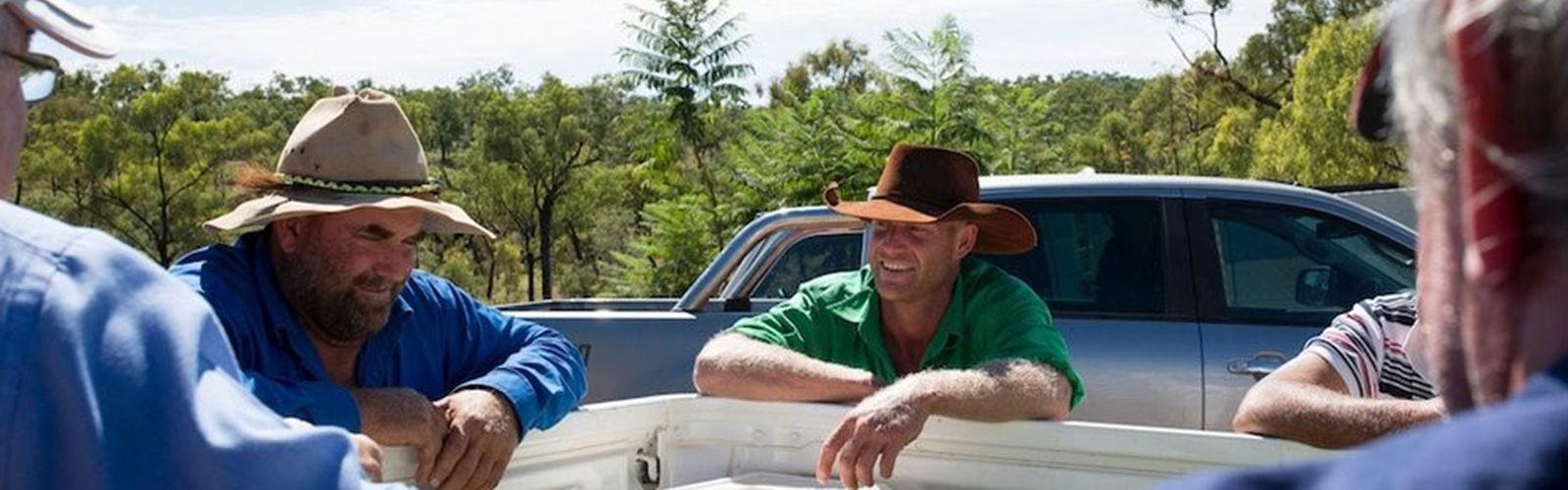 Men talking around ute