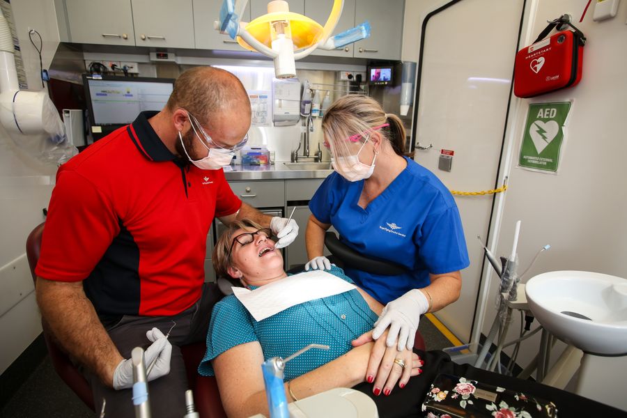 Two RFDS dentists with a patient in a dental van