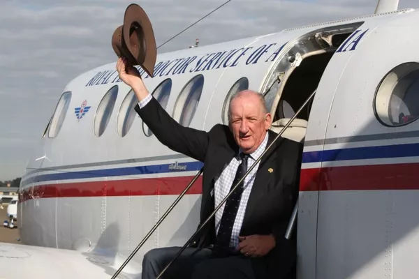 Tim Fischer sits on the steps of an RFDS plane