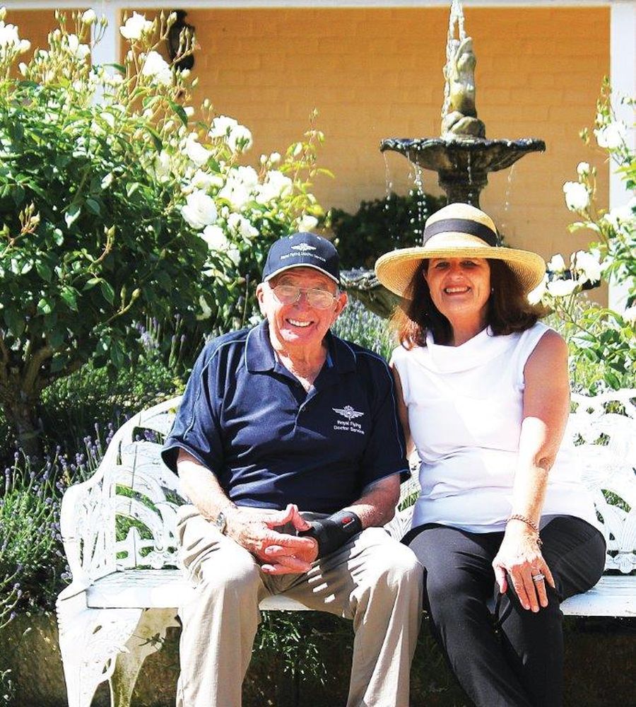 Older man and lady sitting on garden bench