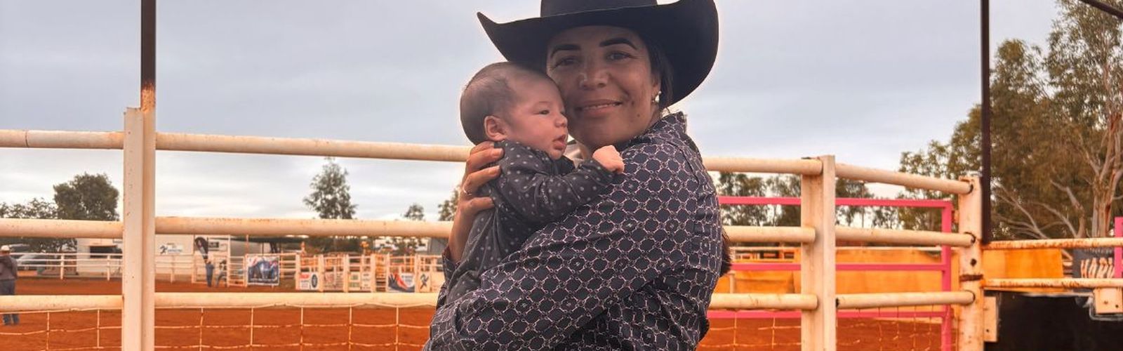 Tui smiling while holding baby Westynn