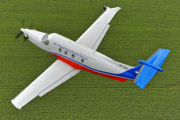 An aircraft with RFDS logo. The sun is setting. 