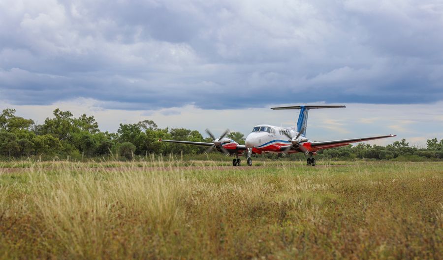 Aircraft on runway with grass in foreground