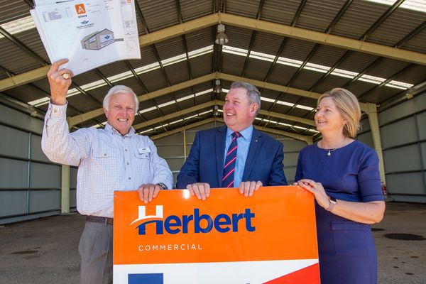 A person lying on a hospital stretcher is pushed toward an aircraft with RFDS logo. 