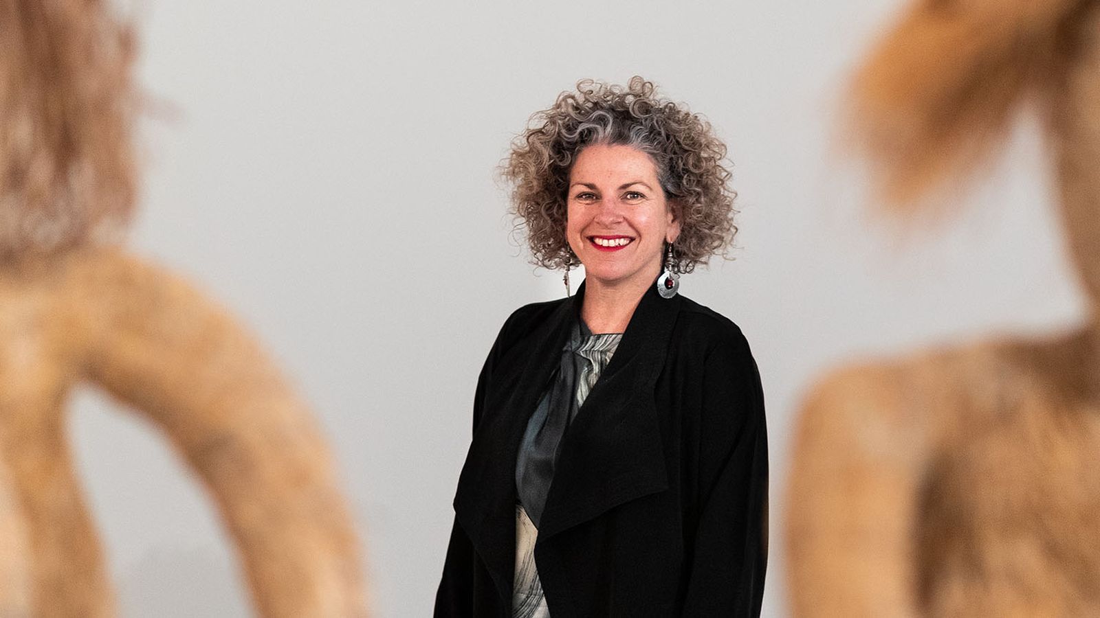 Portrait of Kelli Cole with Tjanpi Desert Weavers sculptures