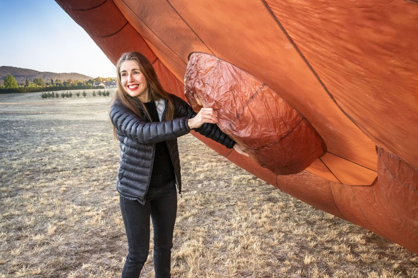 Photo of a person standing beside a hot air balloon