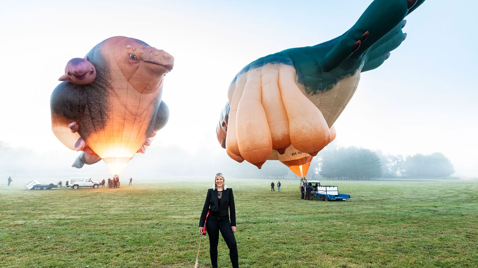 photo of Jess Green holding guitar in front of skywhale balloons