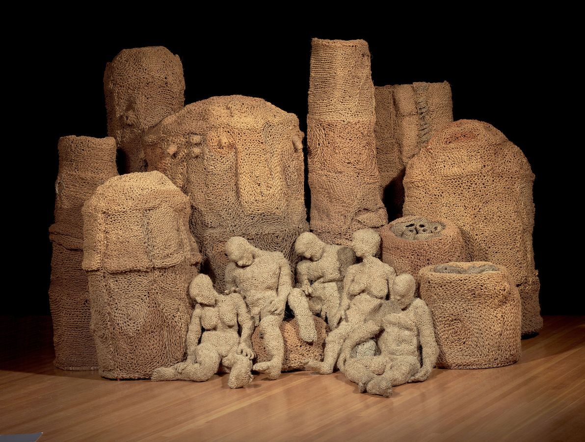 installation photo of sculptures of humans and objects made from woven, crocheted and knitted materials