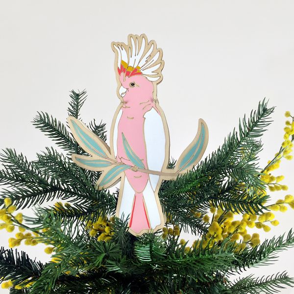 Hand-painted timber Pink Cockatoo ornament sitting on top of Christmas tree.