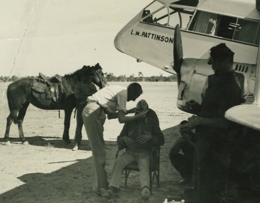 Sister Meg giving health instruction under the shade of the RFDS plane, 1985