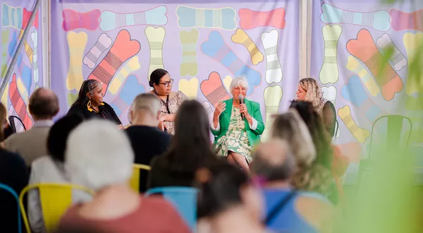 a group of artists talk on a panel discussion in front of a crowd