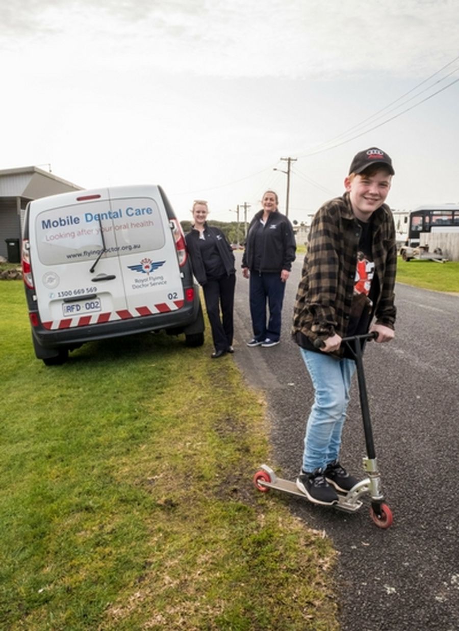 RFDS staff and boy patient on scooter