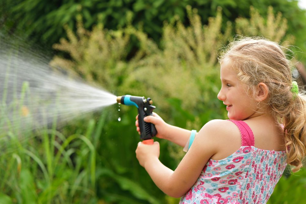 Young girl holding a garden hose