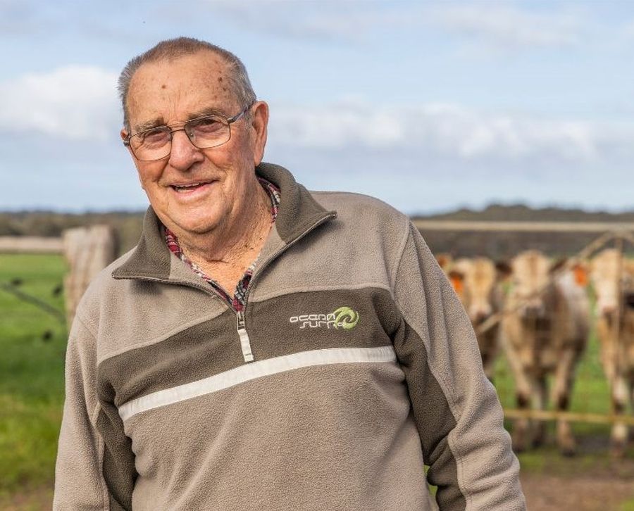George smiling in front of a herd of cows.