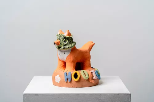 A ceramic figure of a fox wearing a balaclava with the word "hooligan" fixed to the base