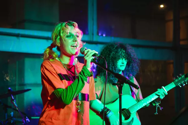 Young person singing into microphone