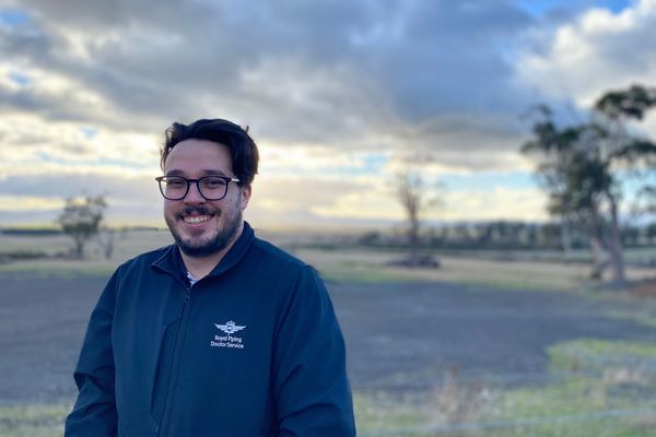 RFDS Tasmania's Physical Health Worker, Lachlan infront of a sunrise.