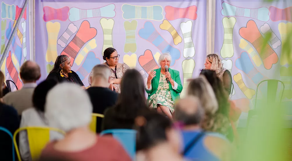 a group of artists talk on a panel discussion in front of a crowd