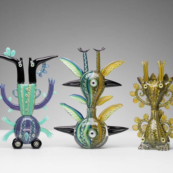 A collection of five creatures made out of glass. Each piece has a distinctive design and all pieces have the legs in the air.