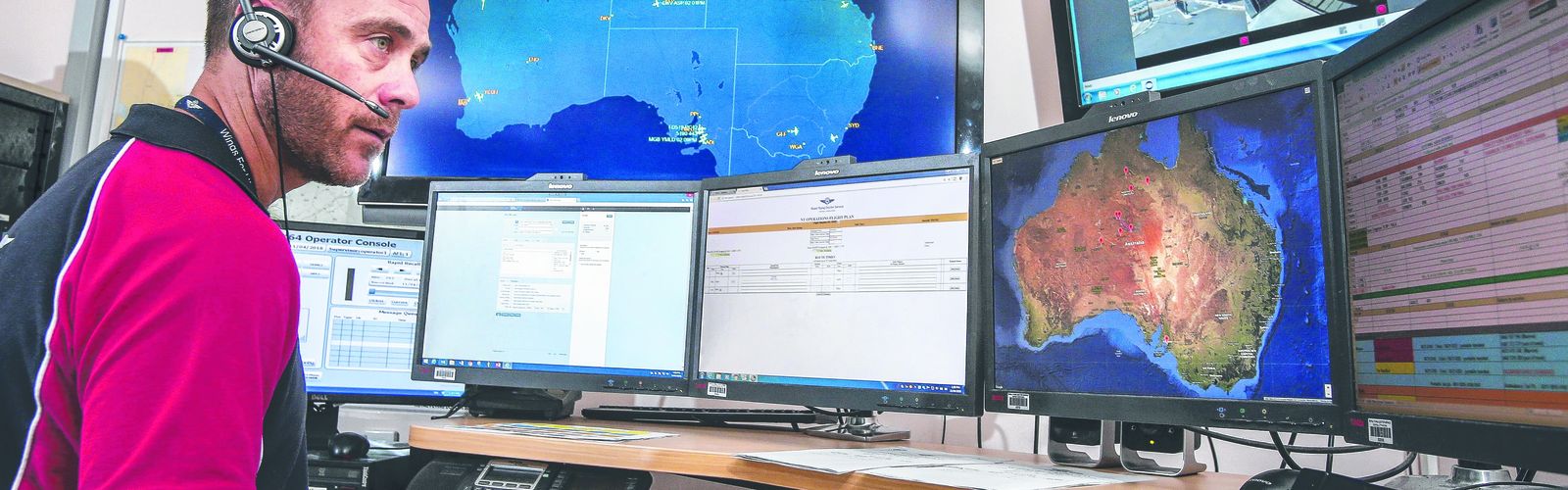 An aircraft with RFDS logo. A patient is lying on a wheeled stretcher, being pushed by a person wearing a high-visibility jacket. 
