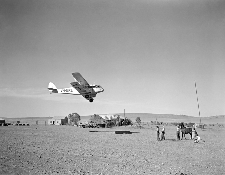 The Barlows look up at the Flying Doctor's De Havilland Dragon departs the Veldt station