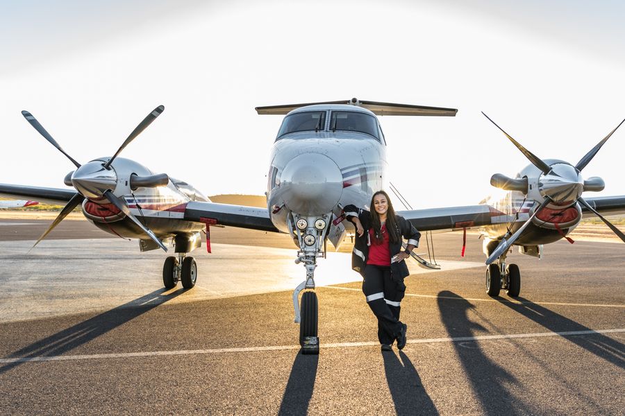 Staff stands next to plane
