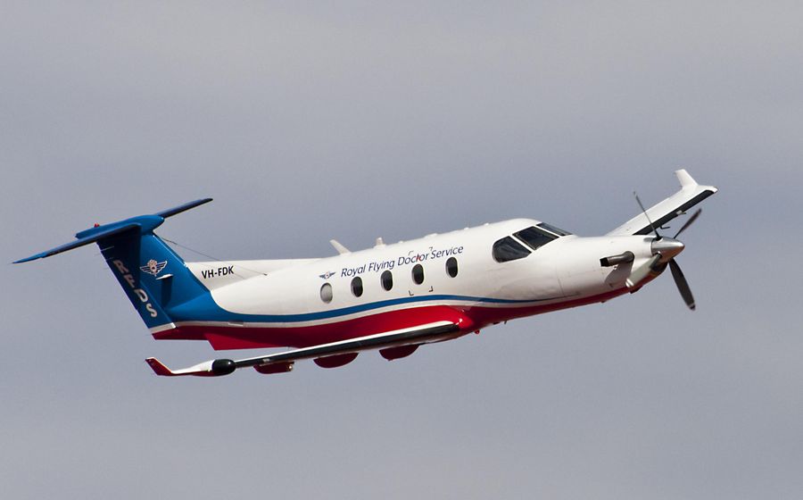 A group of people holding an oversized cheque smile at the camera. The cheque is made out for $10,000 payable to the RFDS. 