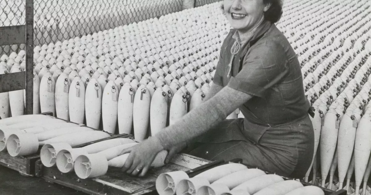 Munitions worker stacking practice bombs - AGSA Collection