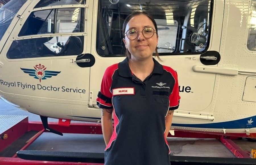 Zoe smiling in front of an RFDS aircraft