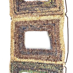 A woven fibre sculpture made from the frame of a burnout car seat.