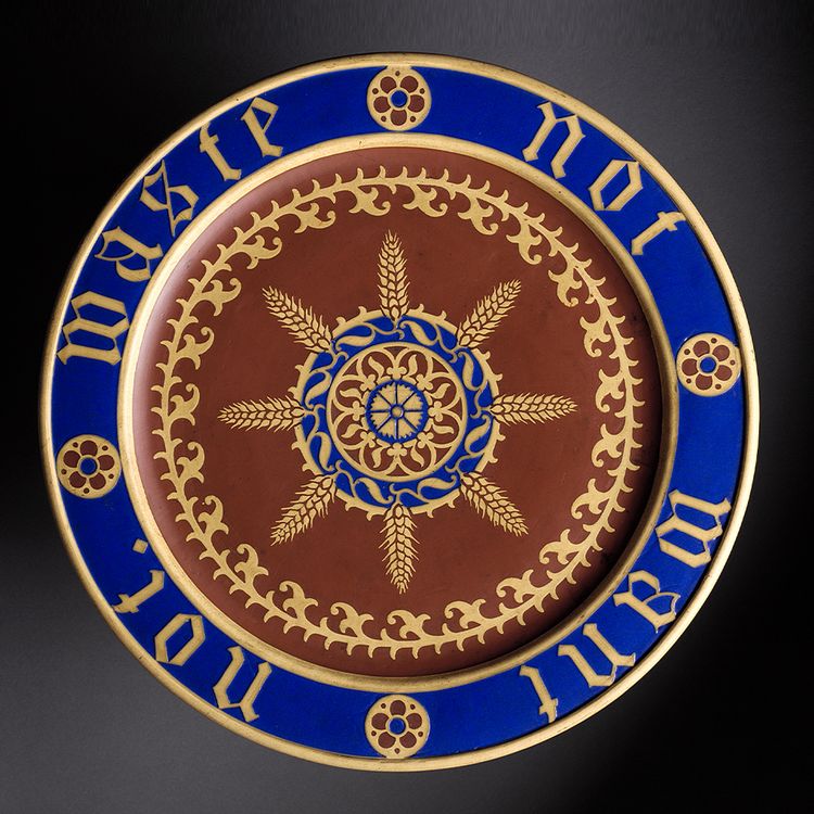 Blue and gold decorated ceramic plate on a grey background