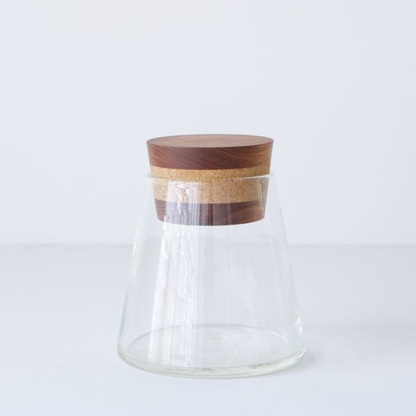 A glass jar with a cork and timber stopper lid