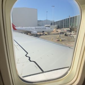 Photo looking out a rounded plane window to the wing.