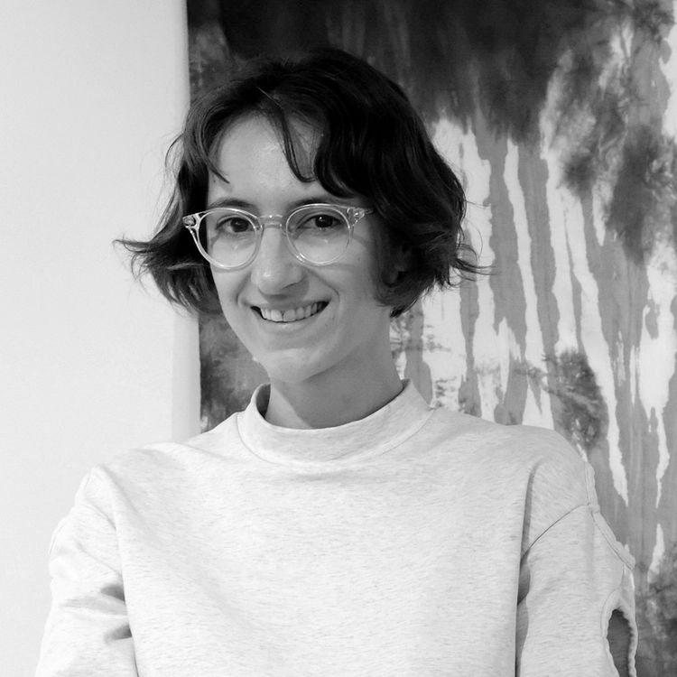 woman with bobbed hair and glasses smiling